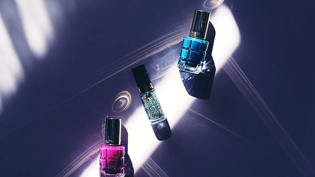 Three nail polish bottles on a deep purple surface under dramatic light